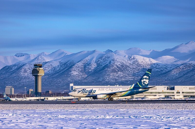 Alaska Airlines plane landing with mountains and control tower in background – Bild: Smithsonian Channel Lizenzbild frei
