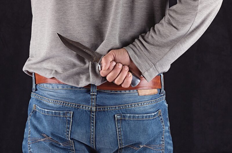 Mann, der hinter seinem Rücken ein Messer hält – Bild: Shutterstock /​ Peyker
