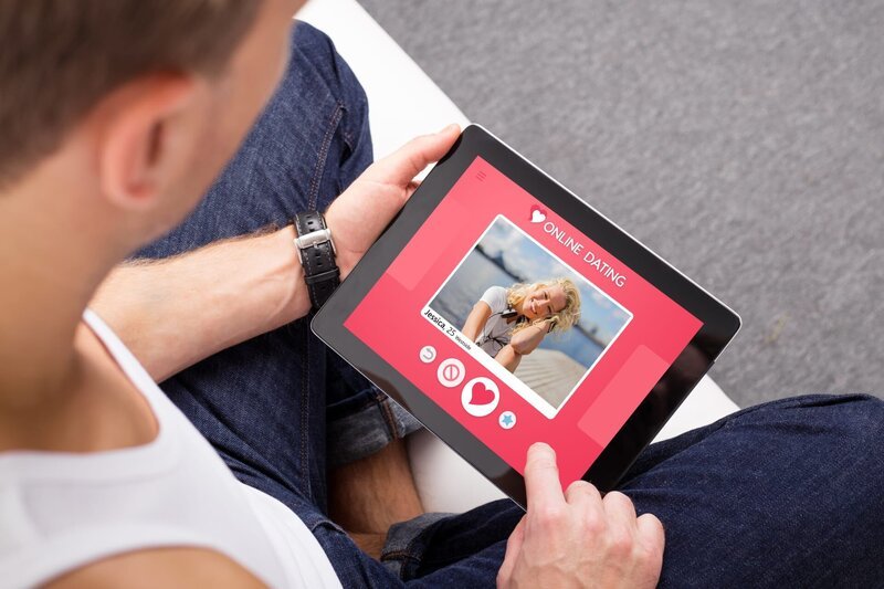 Man using online dating app on tablet – Bild: Shutterstock