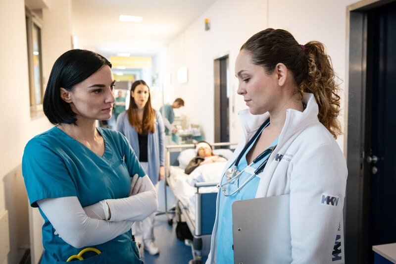 Nora (Mimi Fiedler, l.) und Ella (Ines Quermann) haben eine Auseinandersetzung auf dem Krankenhausgang. – Bild: RTL /​ Christoph Assmann