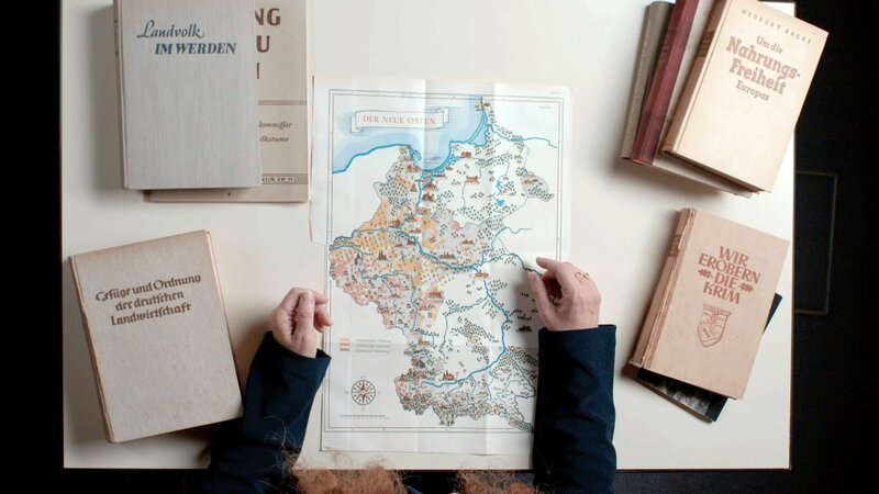 Isabel Heinemann zeigt eine Karte der eingegliederten Gebiete mit den beiden neuen deutschen Reichsgauen „Wartheland“ und „Danzig-Westpreußen“ (Originalpublikation 1941). – Bild: ZDF und ORF/​Hengster Filmproduktion.