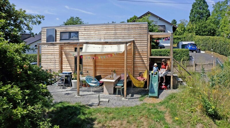 Lena und Alex leben mit ihrer Tochter und zwei Katzen auf 18 Quadratmeter Wohnfläche im Tiny House – mit großem Garten. – Bild: WDR/​Good karma productions/​Marcel Lepel
