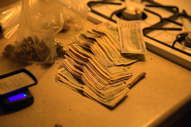 Tütchen mit Cannabis und Geld auf einer Arbeitsfläche. Illustration – Bild: PLURIMEDIA (National Geographic Channels /​ Meg Barnard)
