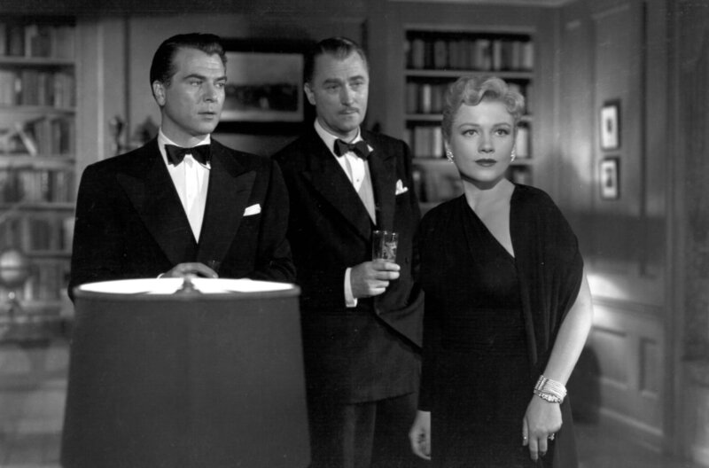 Zum Schweigen verurteilt – Bild: Warner Bros. Pictures /​ Pierre Grandfort (Roger Dann) und Willy Robertson (Brian Aherne) im Smoking mit Ruth Grandfort (Anne Baxter, v.l.)
