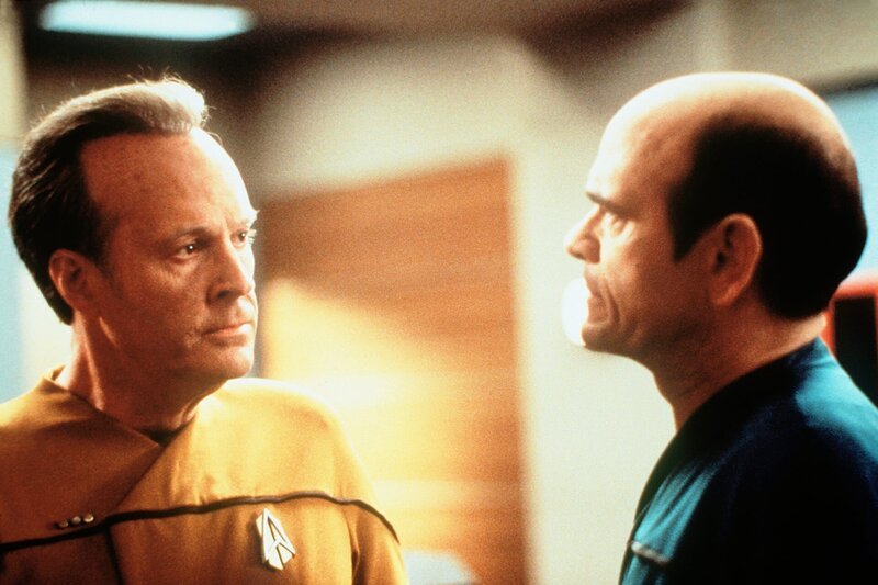 Commander Barclay (Dwight Schultz, l.) und der Doktor (Robert Picardo, r.) überlegen wieder einmal, wie sie die Voyager am schnellsten nach Hause bringen können. – Bild: Tele 5