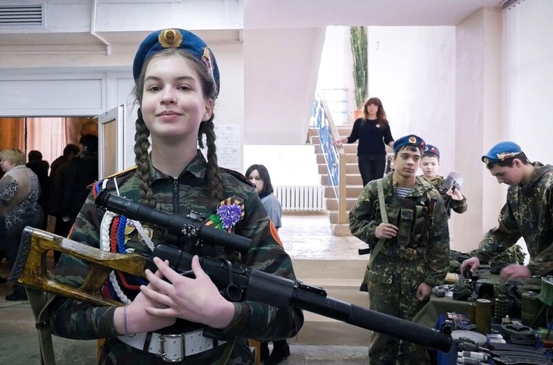 Mascha wurde von ihrer Mutter auf Putin eingeschworen und präsentiert bei der Waffenschau in Jelnja ein Maschinengewehr. – Bild: Dmitry Bogolyubov /​ © Dmitry Bogolyubov