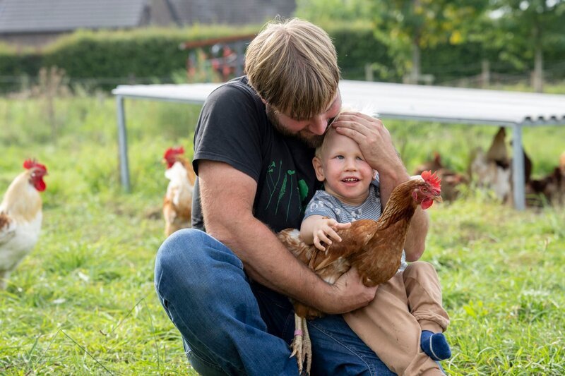 Stephies Ehemann Finn Bönniger mit dem jüngsten Sohn Lenni beim Hühner streicheln. – Bild: WDR/​Melanie Grande/​Melanie Grande