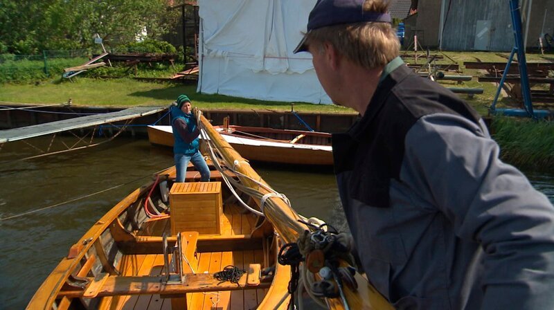 Barabara Wiechmann und ihr 60 Jahre altes Netzboot. „Ich habe diese alten Holzboote schon immer geliebt – mich aber jetzt erst getraut.“ Nach langen Monaten der Restauration bekommt ihr erstes Holzboot seinen Mast. – Bild: NDR