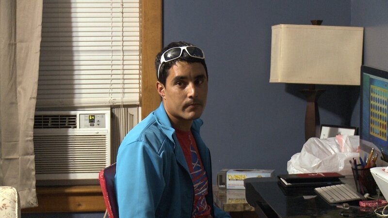 Mohamed sits at the desk in a room. – Bild: Discovery Communications