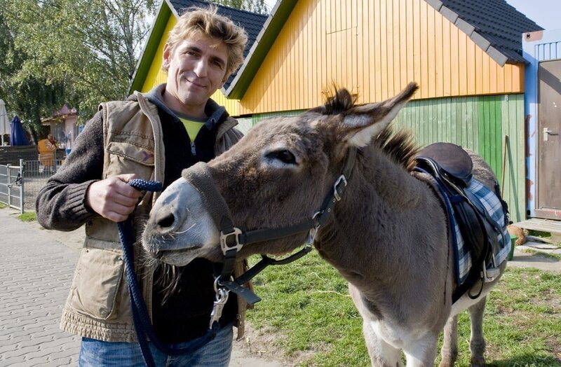 Fritz (Guido Hammesfahr) und der Esel – das neue Team im Tierpark. – Bild: KiKA