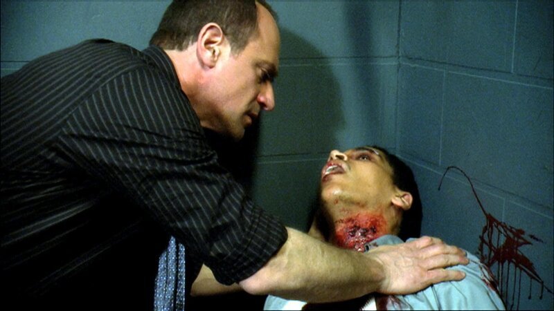 Stabler (Christopher Meloni, li.) kümmert sich um den Verletzten Stefan Henriques (Victor Anthony) … – Bild: 13th Street