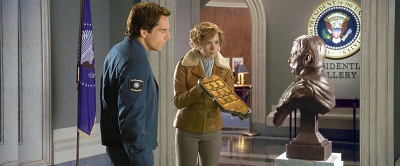 Larry Daley (Ben Stiller) and Amelia Earhart (Amy Adams) consult a bust of Theodore Roosevelt (Robin Williams). – Bild: ORF/​Disney