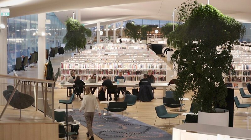 Lesen macht auch glücklich. Vor allem in Helsinkis neuer Zentralbibliothek Oodi. Wer nicht lesen will, kann auch 3D-Drucken, nähen oder Musik machen. – Bild: ZDF und NDR.