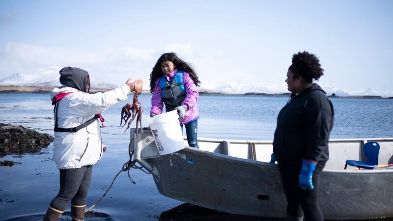 Marcella Amodo-White mit ihren Kindern beim Sammeln von Nahrungsmitteln aus den Fluten. (National Geographic/​Ashton Hurlburt) – Bild: National Geographic /​ Ashton Hurlburt /​ National Geographic/​Ashton Hurlburt