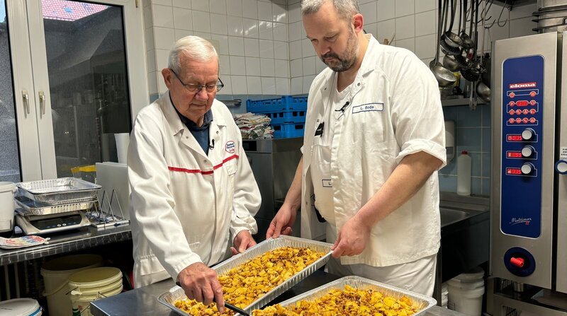 Spät am Abend steht der Fleischer noch in seiner Partyservice-Küche – sein Vater Bernd hilft wo er kann. – Bild: ZDF und NDR/​Kamera Zwei.