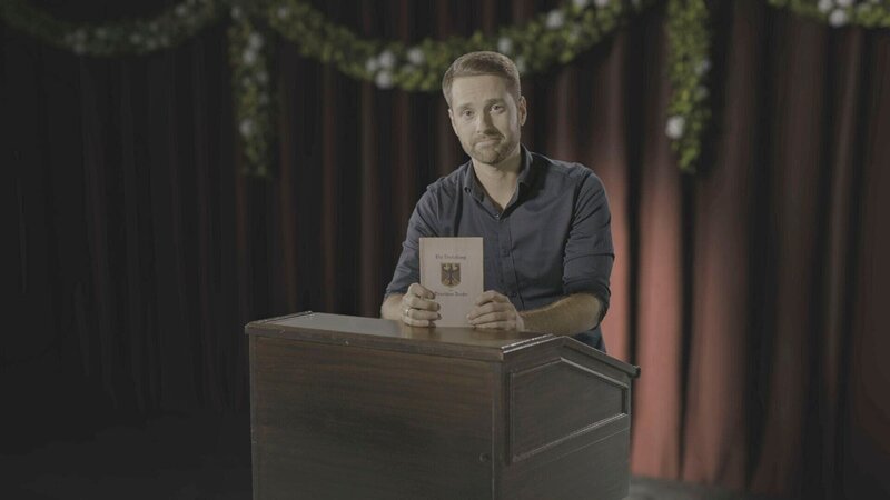 Mirko Drotschmann hält die Verfassung der jungen Republik in den Händen. – Bild: ZDF und BPK.