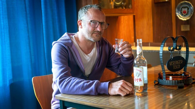 Gabriel Panski (Maximilian Brückner) trinkt an seinem eigenen Tisch. – Bild: ARD Degeto/Boris Laewen Gabriel Panski (Maximilian Brückner) trinkt an seinem eigenen Tisch. – Bild: ARD Degeto/Boris Laewen