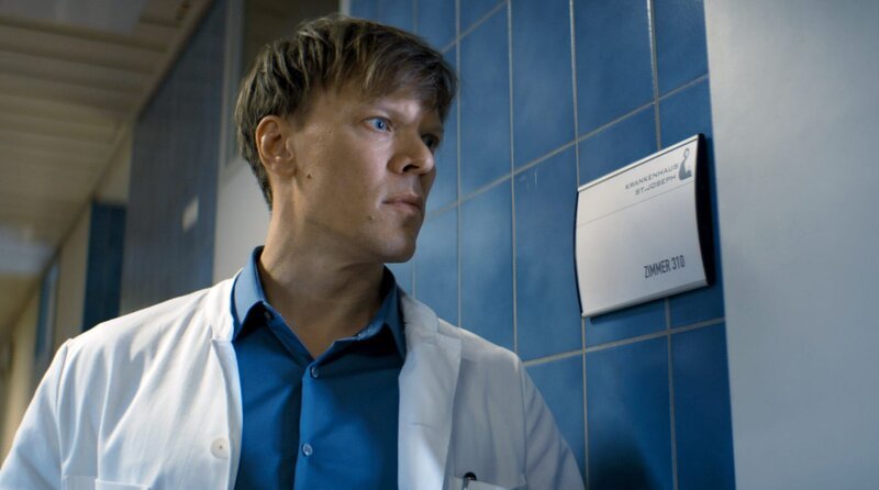 Dr. Ludwig (Sebastian Hülk) achtet besonders auf eine Patientin. – Bild: Barry Films/​Mona Film/​Stephan Burchardt