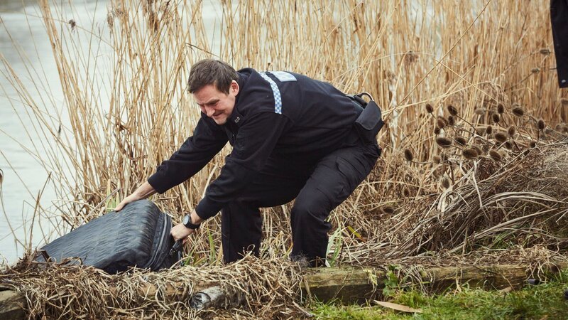 Sean Cobley (Anthony Flanagan) zieht einen verdächtigen Koffer aus dem Fluss. – Bild: ZDF und Matt Frost./​Matt Frost