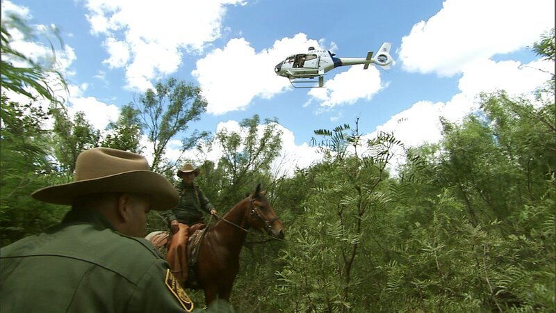 Laredo, TX: Two Customs and Border Protection agents patrolling on horseback and working with agents in a helicopter above. – Bild: National Geographic Channels /​ NGT