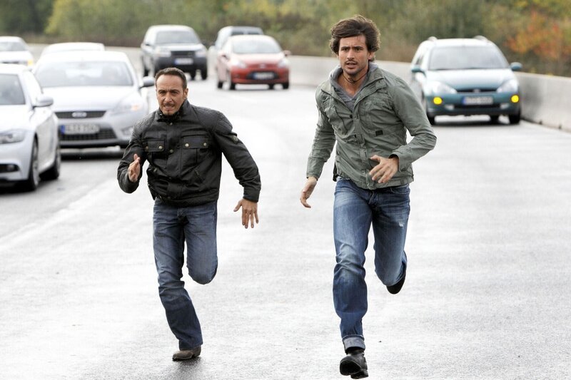 Semir (Erdogan Atalay, l.) und Ben (Tom Beck) werden Zeuge, wie Laras Ente auf der Autobahn einen Massencrash verursacht und müssen sich mit einen Sprung in Sicherheit bringen … – Bild: RTL /​ Guido Engels