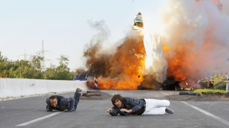 Semir (Erdogan Atalay, l.) und Ben (Tom Beck) konnten sich in letzter Sekunde vor dem explodierenden Streifenwagen in Sicherheit bringen … – Bild: RTL /​ Guido Engels