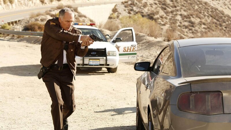 Sheriff Gardner (Patrick St. Espirit) nähert sich dem offenbar verlassenen Auto mit äußerster Vorsicht. – Bild: MG RTL D