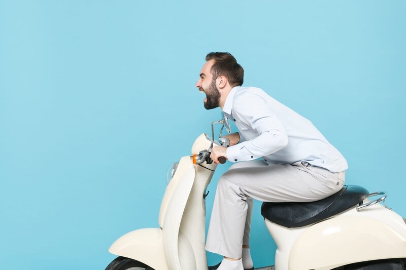 Side view of crazy screaming young bearded man guy in casual light shirt driving moped isolated on pastel blue background studio portrait. Driving motorbike transportation concept. – Bild: Shutterstock /​ Shutterstock /​ Copyright (c) 2020 ViDI Studio/​Shutterstock. No use without permission.
