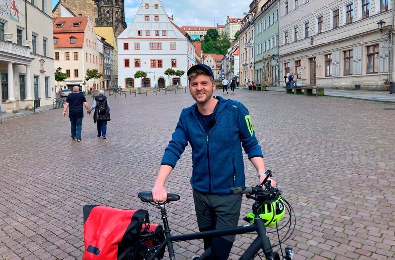 Action und Idylle, Großstädte und verschlafene Dörfer – wer auf dem insgesamt 1.300 Kilometer langen Elberadweg unterwegs ist, bekommt all das geboten. Lohnt es sich individuell zu planen oder fährt man mit einer pauschal gebuchte Gruppenreise besser? Um das herauszufinden, fährt Johannes Zenglein von Bad Schandau bis nach Mühlberg. – Johannes Zenglein in der Altstadt von Pirna am Elberadweg. – Bild: WDR/​SWR/​Bavaria Entertainment GmbH