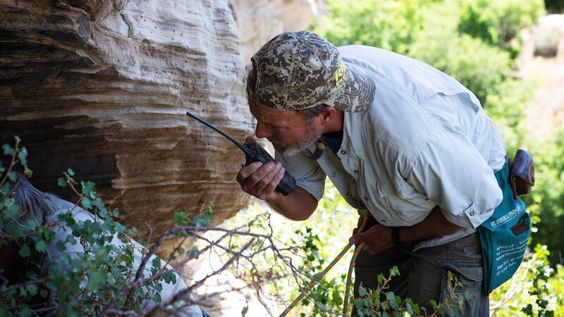 Eric Drummond looks into the cave, talking into his walkie talkie. – Bild: presse.discovery.de