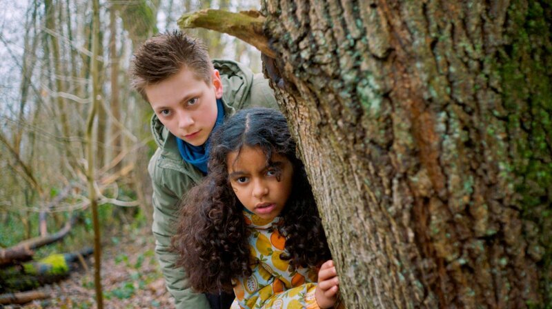 Moritz (Jan Friedrichsen) und Amy (Melody Rose) beobachten eine Giftmüllentsorgung im Wald. – Bild: NDR