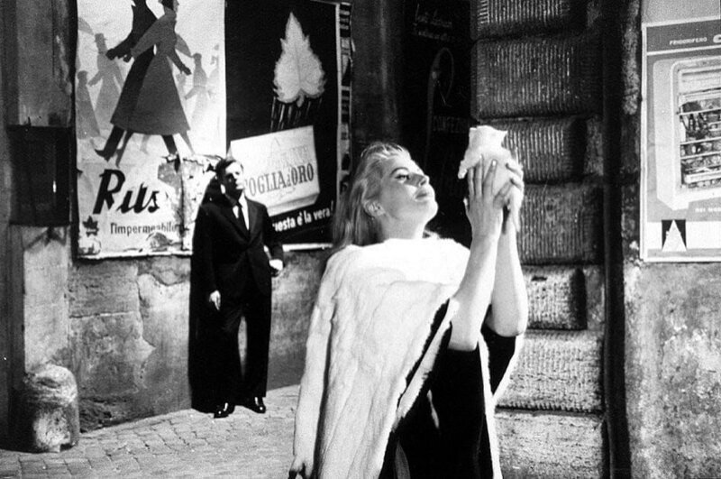 Als Sylvia (Anita Ekberg) nachts allein mit Marcello (Marcello Mastroianni) durch Rom zieht und in den berühmten Trevi-Brunnen steigt, folgt er ihr fasziniert. – Bild: Marlyse Press Photo/​MPP
