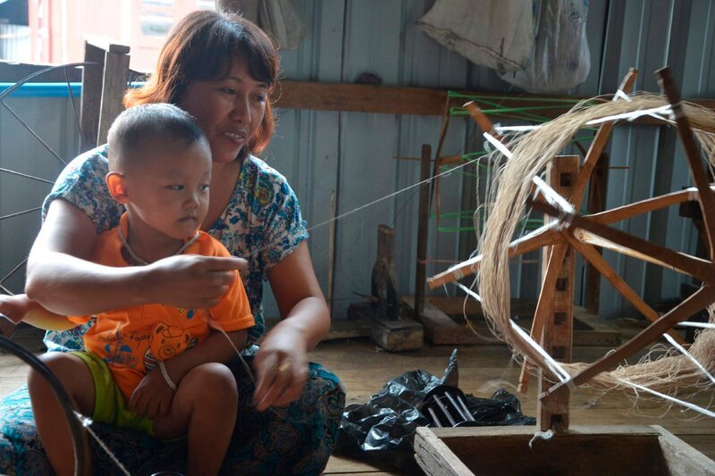 Die Lotosweberin Daw Chaw mit ihrem Neffen an der Spindel. – Bild: Anna-Lena Maul /​ BR, MDR, Arte /​ Arte/​BR/​MDR/​Anna-Lena Maul