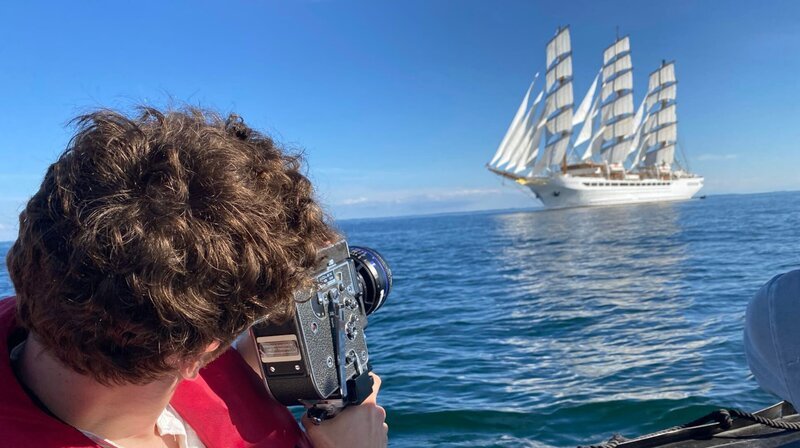 Bei der sogenannte Fotosafari filmt Passagier und Filmstudent Sebastian Ganschow die Sea Cloud Spirit unter vollen Segeln. – Bild: NDR/​Mario Göhring