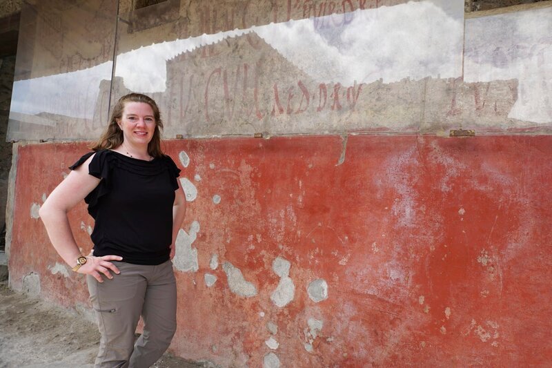 Prof. Rebecca Benefiel – Roman Historian – in front of an election Graffiti in Pompeii. – Bild: Blink Films
