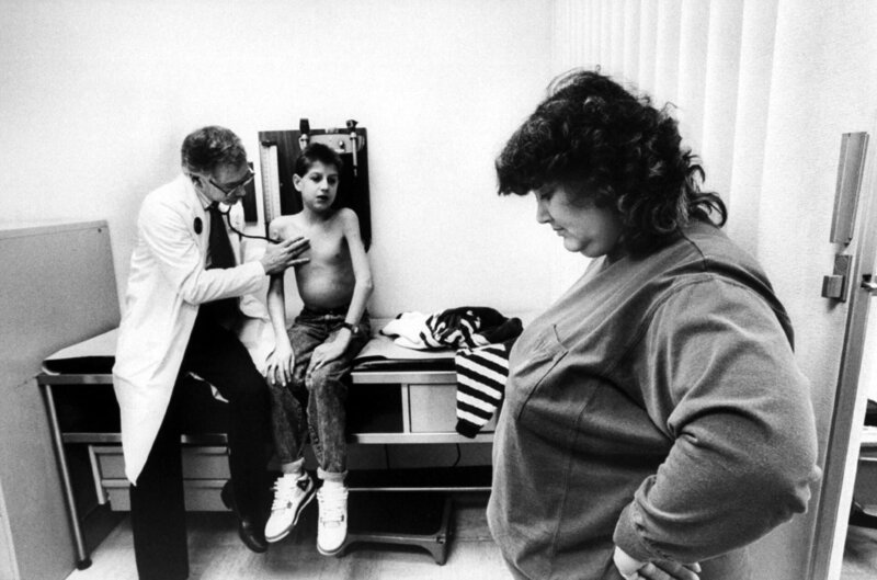 AIDS Ryan White sitting w/​o shirt on examining table as his physician Dr. Martin Kleiman uses a stethoscope to listen to his lungs while mom Jeanne sadly looks on at hospital. (Photo by Taro Yamasaki/​The LIFE Images Collection/​Getty Images) – Bild: National Geographic