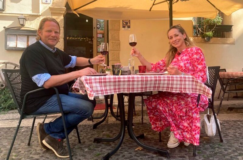 Björn Freitag und Tamina Kallert stoßen vor der Hostaria Vecchia Fontanina auf ihre kulinarische Reise durch Verona an. – Bild: WDR/​2bild/​Fabian Nast