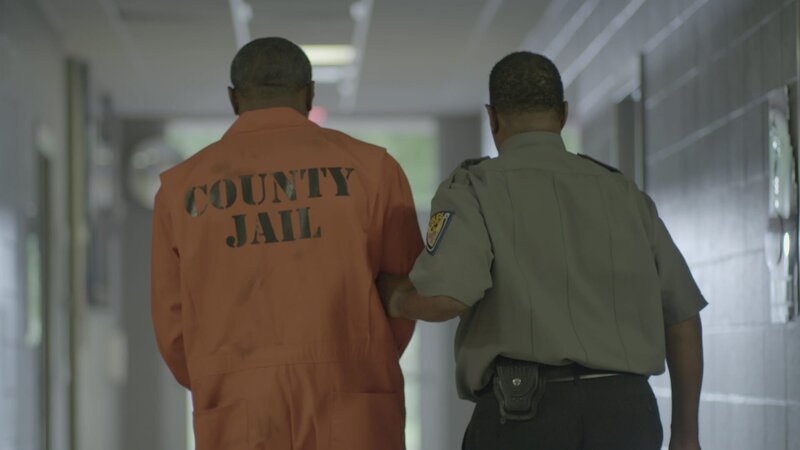 A prisoner being walked down hallway by guard – Bild: Discovery Communications