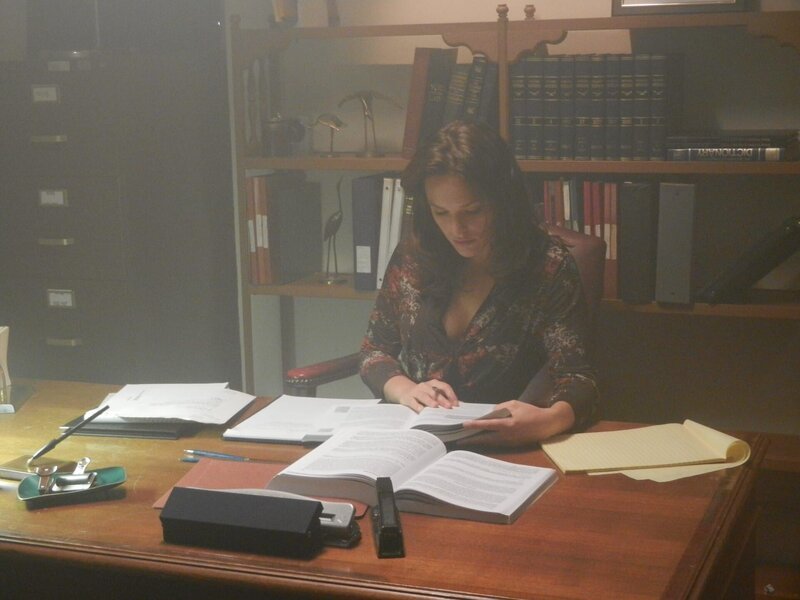 Melissa Bayern is (Margaret) sitting at her desk reading a book. – Bild: TLC