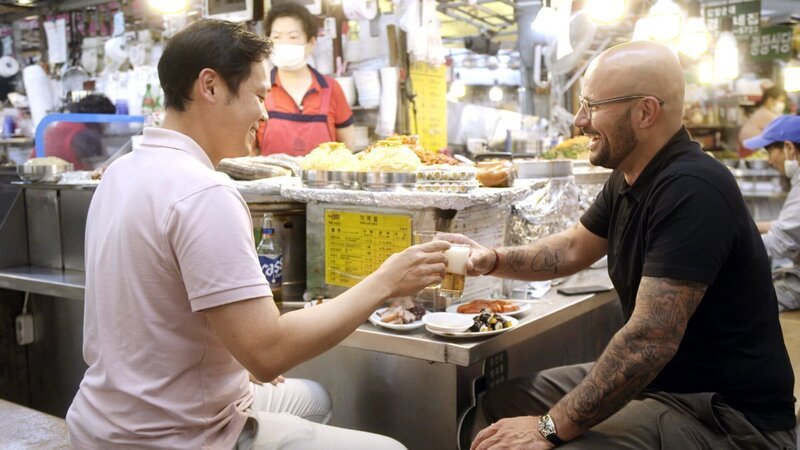 Auf dem Gwangjang-Markt in Seoul probieren sich Carlton McCoy (r.) und Kyungmoon Kim (l.) durch verschiedene Speisen und Getränke. – Bild: SRF/​Fremantle