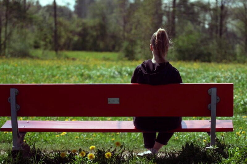 Puls Darauf sollten Eltern bei der Trennung achten? Eine Jugendliche sitzt allein auf einer Bank. SRF – Bild: SF1