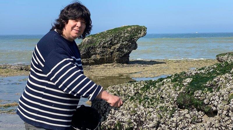 Ein seltenes Handwerk an der Steilküste südlich von Calais. Myriam Pont ist eine Muschelfischerin, die mit einem speziellen Suppenlöffel die Miesmuscheln von den Felsen hebelt. – Bild: NDR/​Katrin Heineking