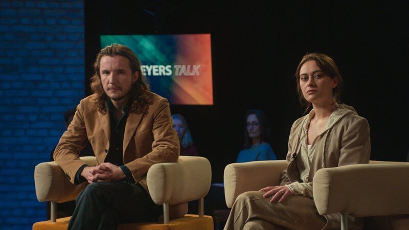 Max (Leonard Carow) und Lou (Mercedes Müller) sitzen in der Talkshow und sprechen über ihre Sterilisierung. – Bild: Hamburg Media School, BR /​ BR/​Hamburg Media School