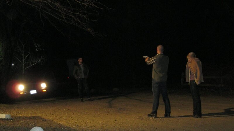Actor pointing gun at other actor standing in headlights. Recreation: On Valentine’s Day 2010, a horrific scene occurs in a nearby parking lot, which the two little daughters of the quarreling couple have to watch helplessly. – Bild: TLC