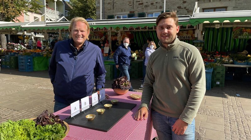 Auf einem Markt in Ratingen lässt Björn Freitag (l) verschiedene Salatsaucen verkosten. – Bild: WDR/​solis TV