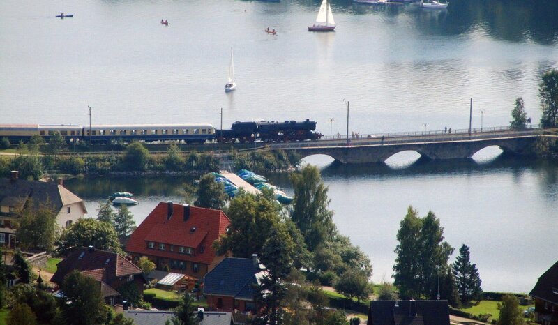 Der Dampfsonderzug der 3-Seen-Bahn überquert das einzige Vidadukt der Hochschwarzwaldstrecke beim Ort Schluchsee. Bis in die 30er Jahre waren die Pfeiler über 30 m hoch; durch die Aufstauung des Schluchsees verschwand die Brücke fast. Regelmäßig im Sommer und zum Jahreswechsel fährt der Dampfzug auf der 19 km langen Strecke für Touristen wie vor 60 Jahren. – Bild: SWR/​Bernhard Foos