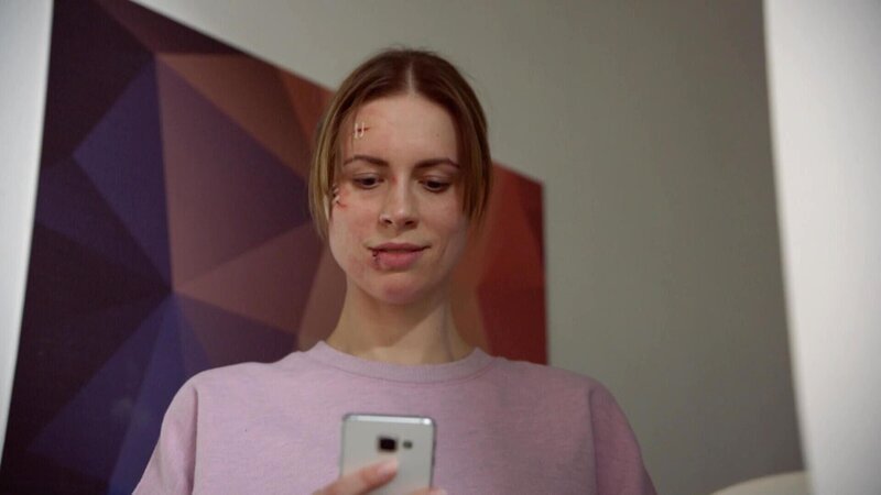 Zoe (Lara Dandelion Seibert) erhält ein Handy-Video und freut sich, dass es ihrem Kind gut geht. +++ – Bild: ${image.CopyrightShort} { image.CopyrightLong}