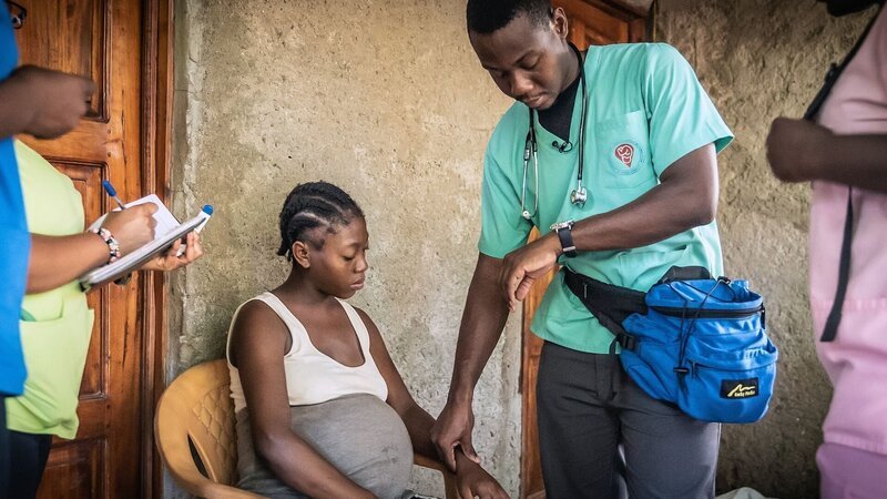 Geburtshelfer Edouard untersucht eine Schwangere in einem Slum im Süden Haitis. Die junge Mutter kann sich weder die Vorsorge noch die Geburt in einem Krankenhaus leisten. – Bild: Anja Booth /​ © Anja Booth
