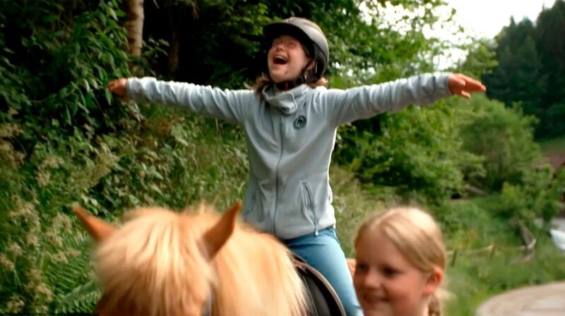 Rosalie sitzt auf einem Pferd, streckt die Arme aus und ruft „Freiheit“. – Bild: SWR/​SEO Entertainment