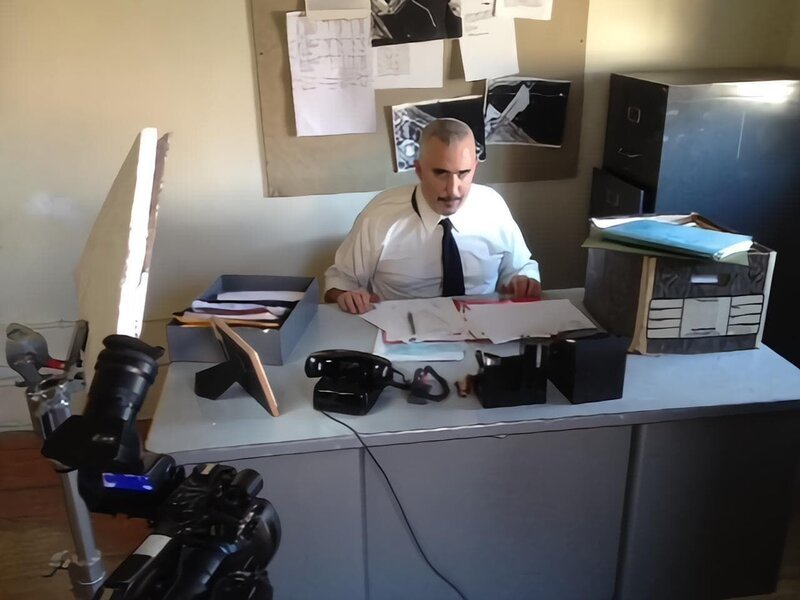Detective Buchanan (Actor, Joe Badalamente) is sitting behind a desk. – Bild: Investigation Discovery /​ Discovery Communications